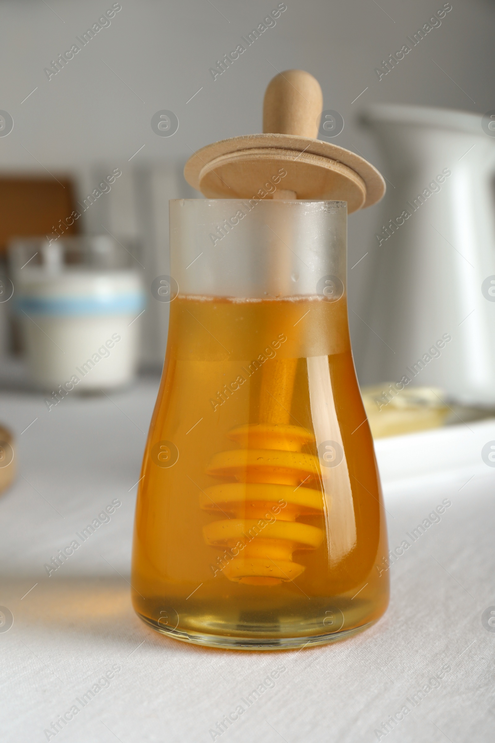 Photo of Jar of tasty honey on white table