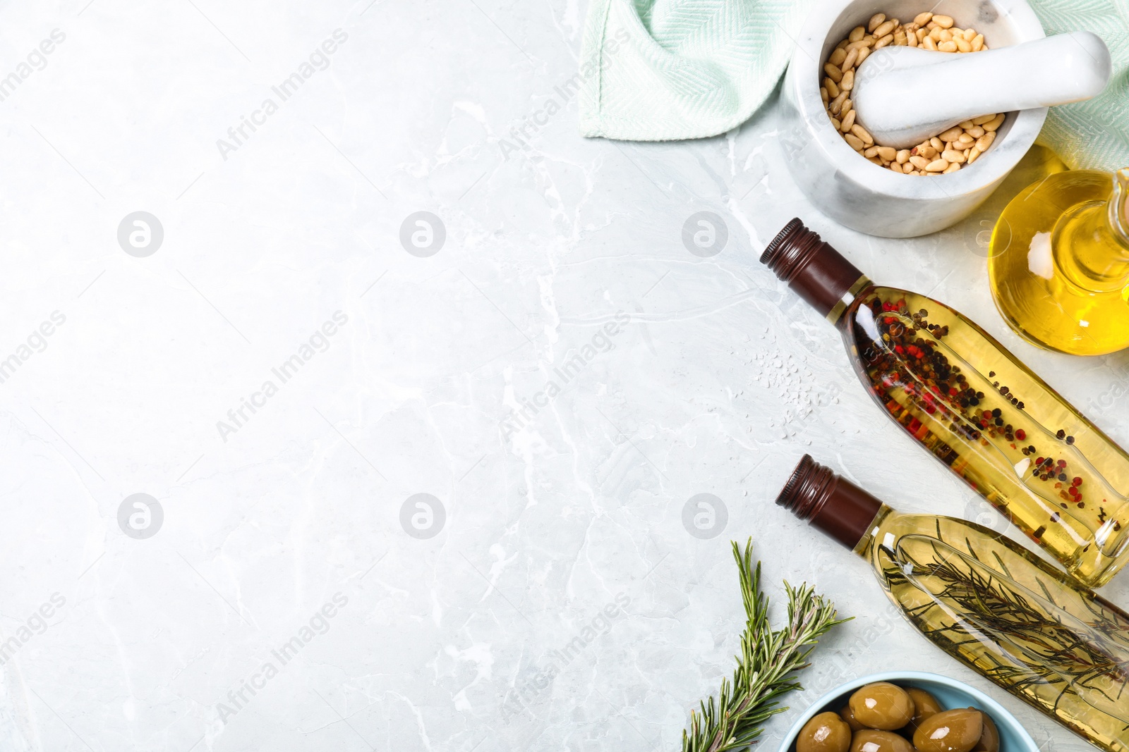 Photo of Flat lay composition with different sorts of cooking oil on grey marble table. Space for text