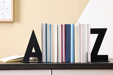 Minimalist letter bookends with books on table indoors