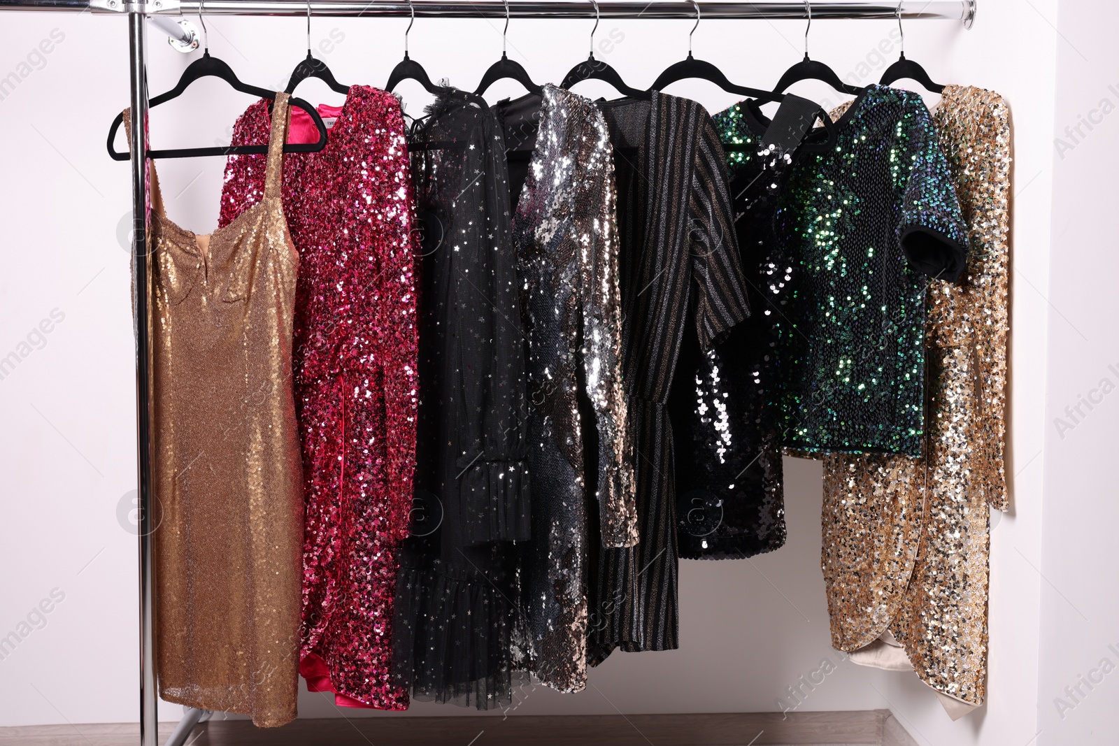 Photo of Collection of different beautiful women's party dresses on hangers in showroom. Stylish trendy clothes for high school prom