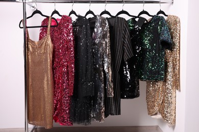 Photo of Collection of different beautiful women's party dresses on hangers in showroom. Stylish trendy clothes for high school prom