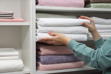 Photo of Customer choosing towels in linen shop, closeup