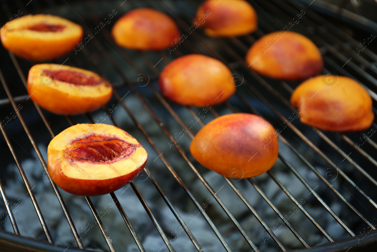 Photo of Modern grill with tasty cut peaches, closeup