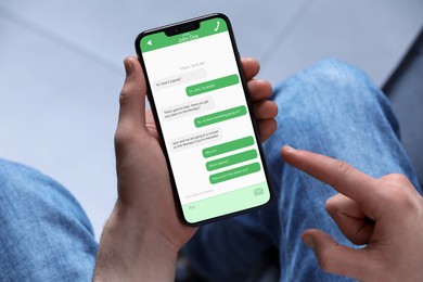 Image of Man texting via mobile phone indoors, closeup. Device screen with messages