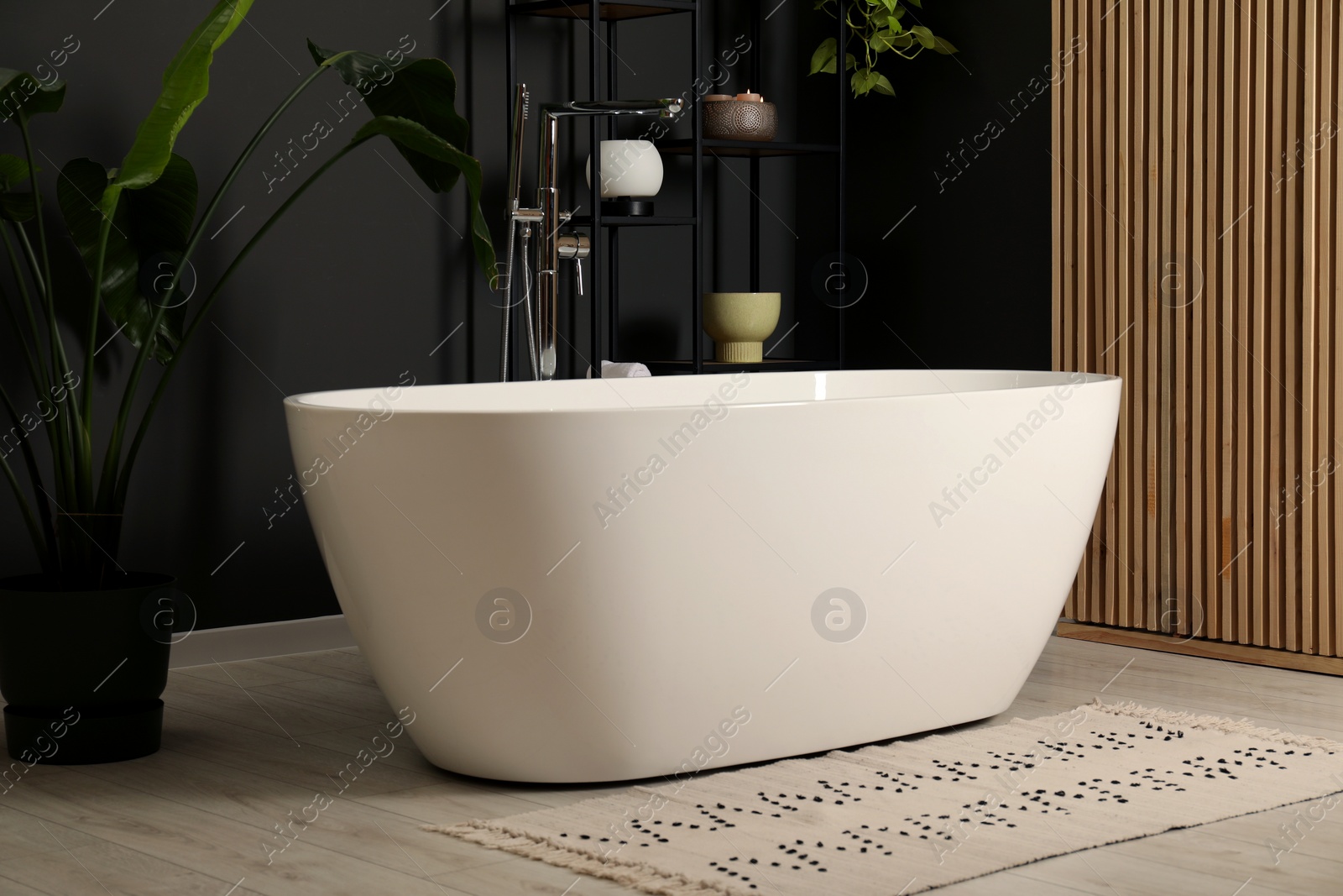 Photo of Spa day. Stylish bathroom with ceramic tub and houseplant