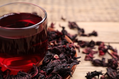 Photo of Fresh Hibiscus tea on wooden table, closeup