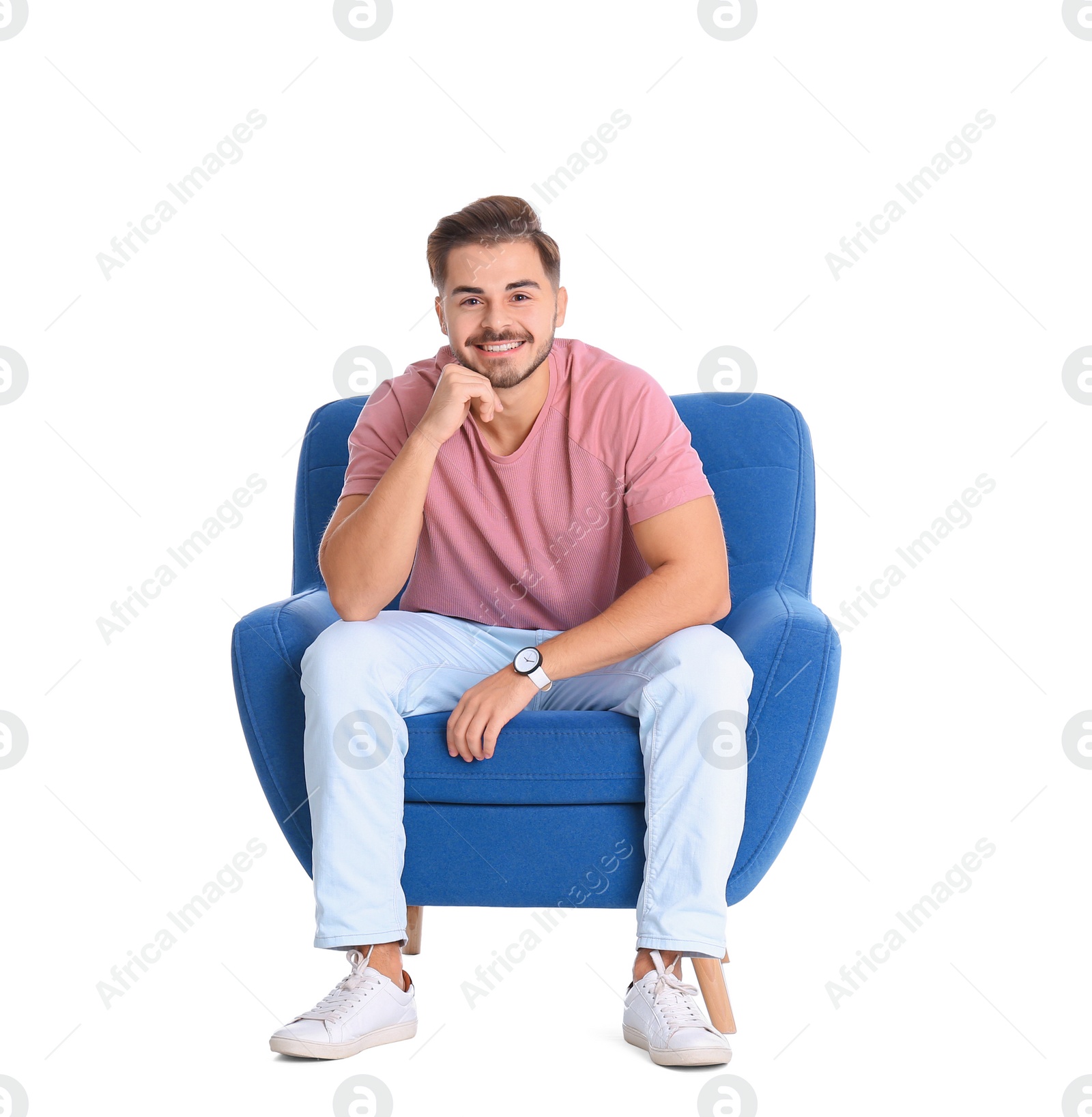 Photo of Handsome young man sitting in armchair on white background