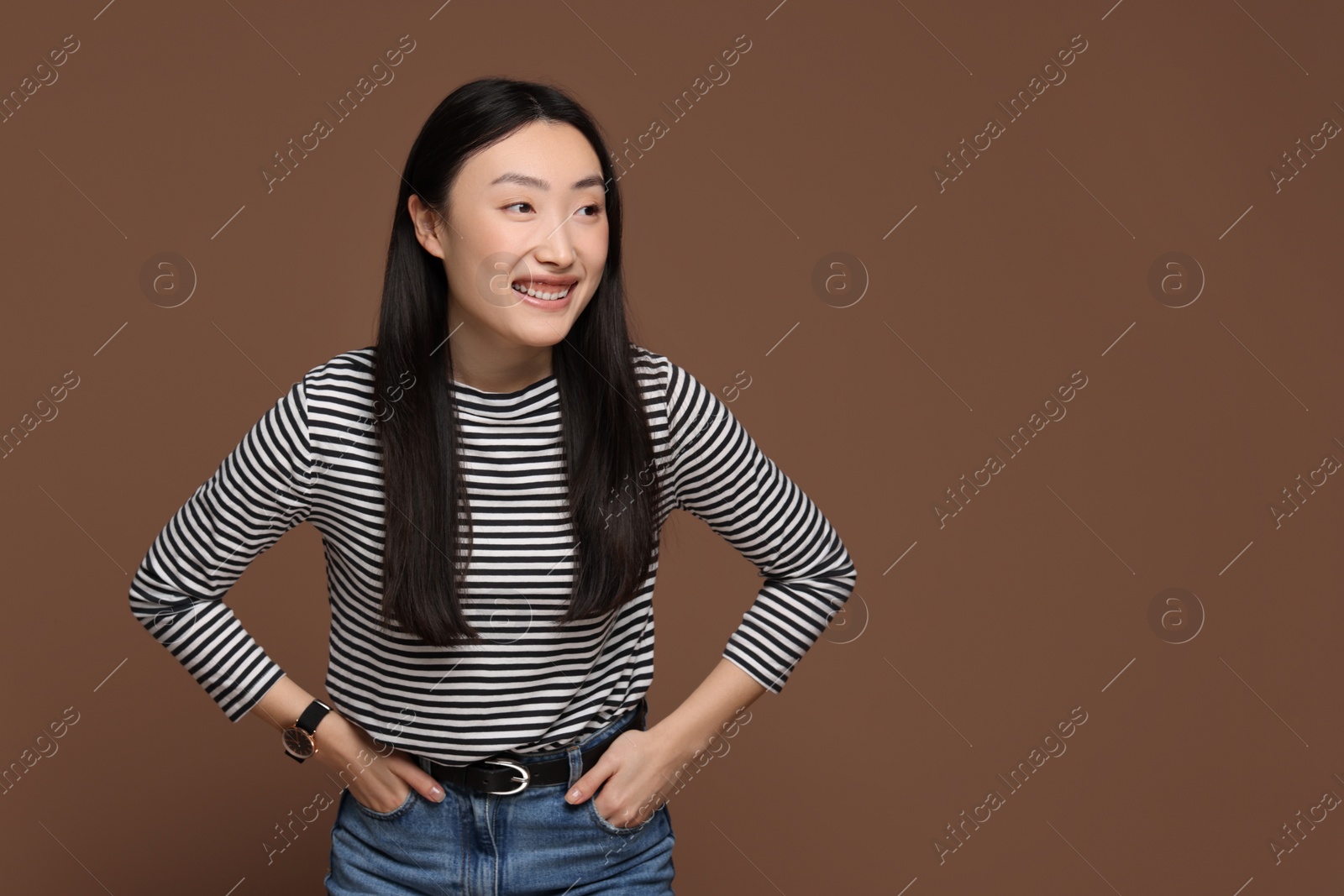 Photo of Portrait of smiling woman on brown background. Space for text