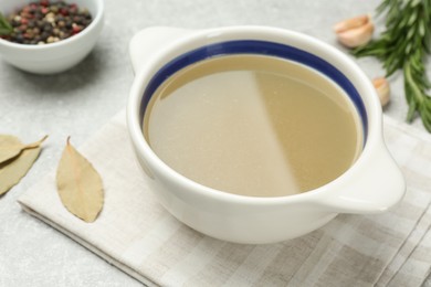 Photo of Bowl with delicious bone broth on light grey table