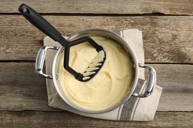 Photo of Pot of freshly cooked homemade mashed potatoes on wooden table, top view