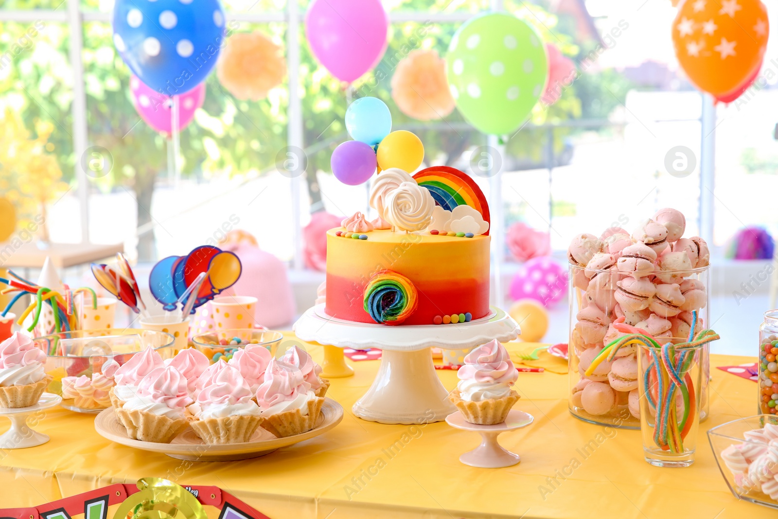 Photo of Table with birthday cake and delicious treats indoors