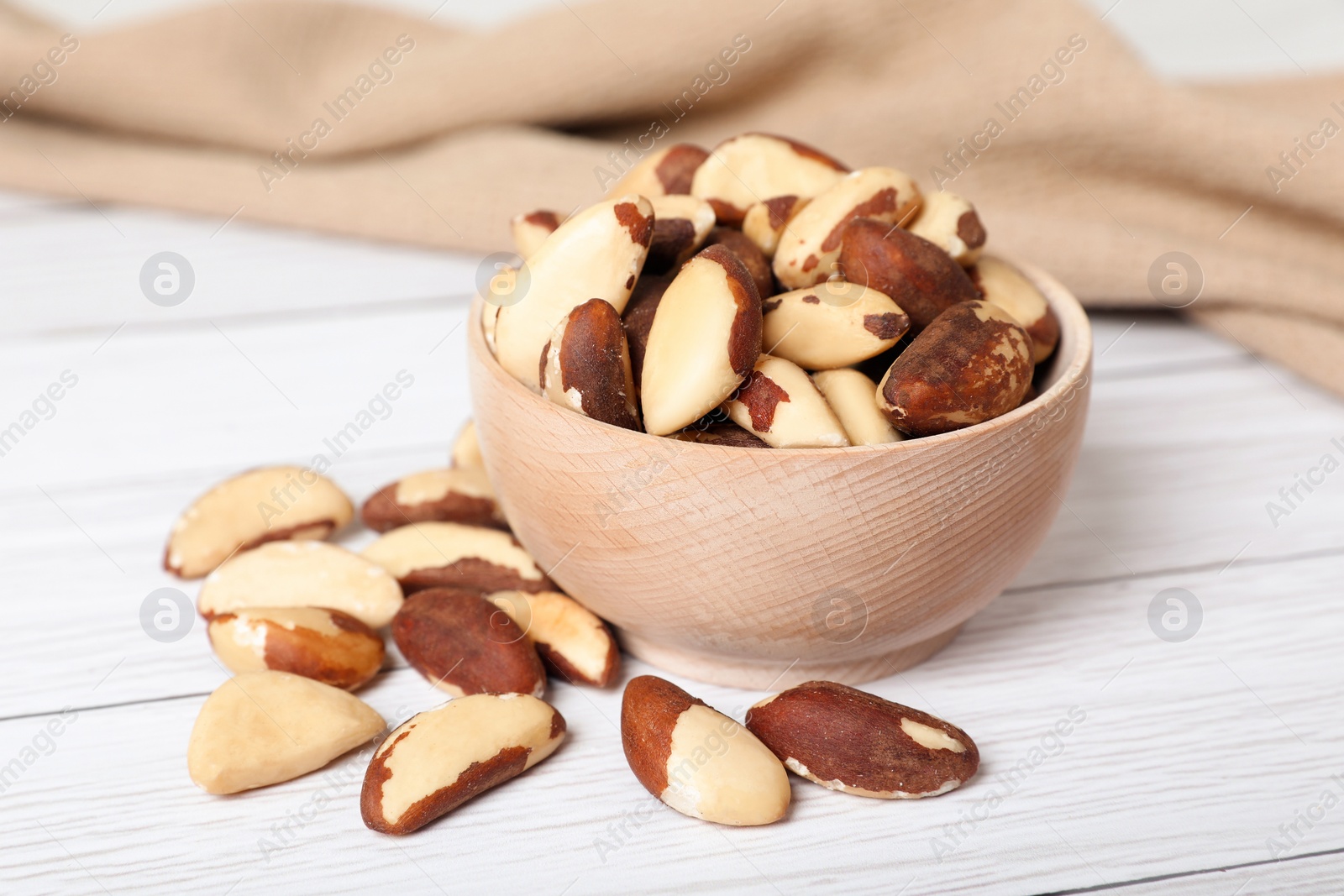 Photo of Delicious Brazil nuts on white wooden table