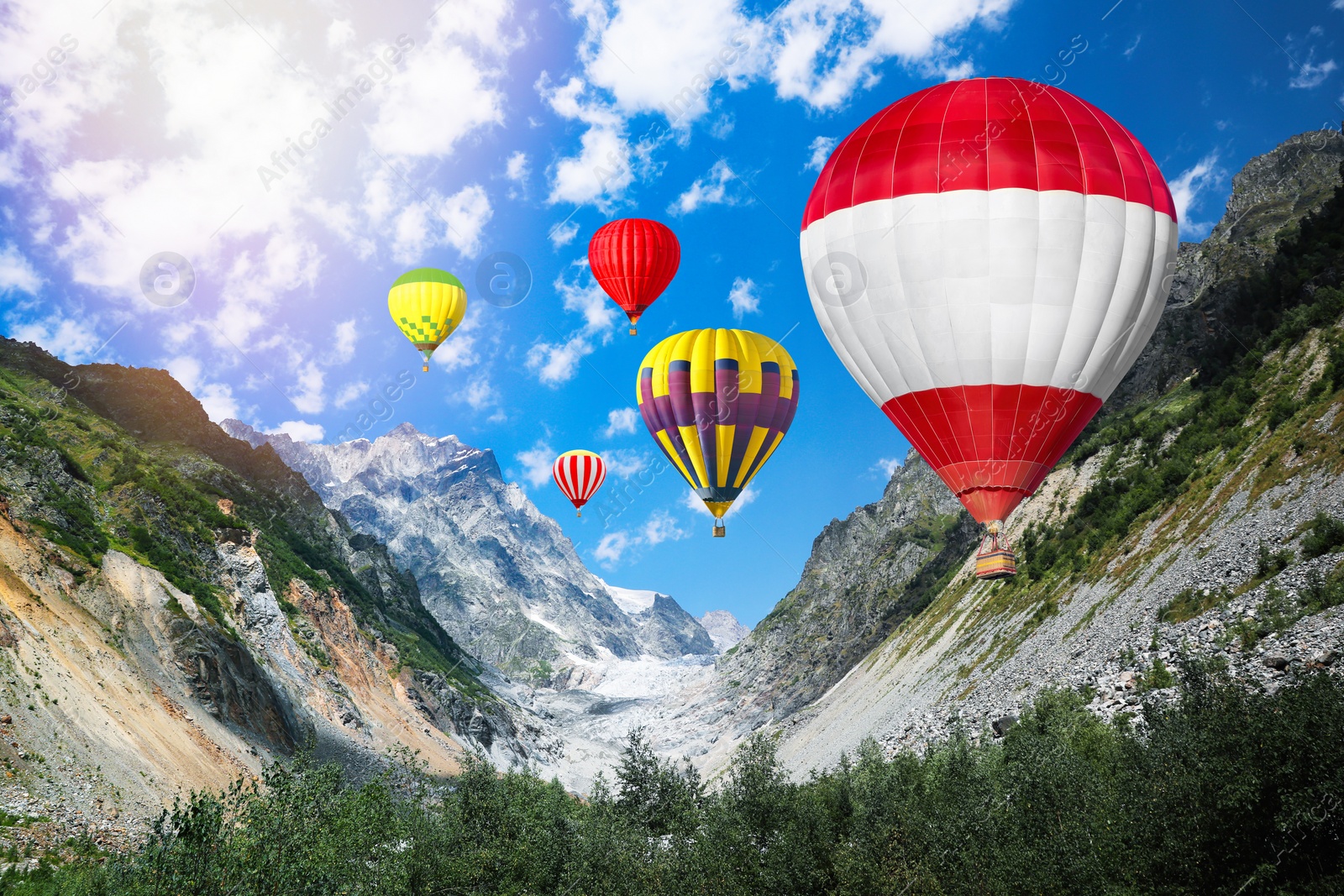 Image of Bright hot air balloons flying in mountains