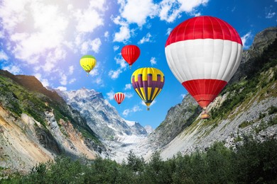 Image of Bright hot air balloons flying in mountains