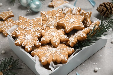 Photo of Tasty Christmas cookies and festive decor on light grey table, closeup