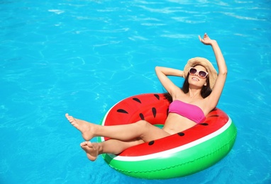 Photo of Beautiful young woman with inflatable ring in swimming pool