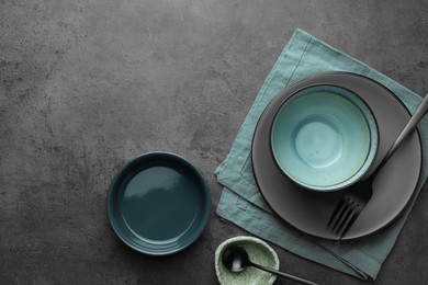 Photo of Stylish empty dishware and cutlery on grey table, flat lay. Space for text