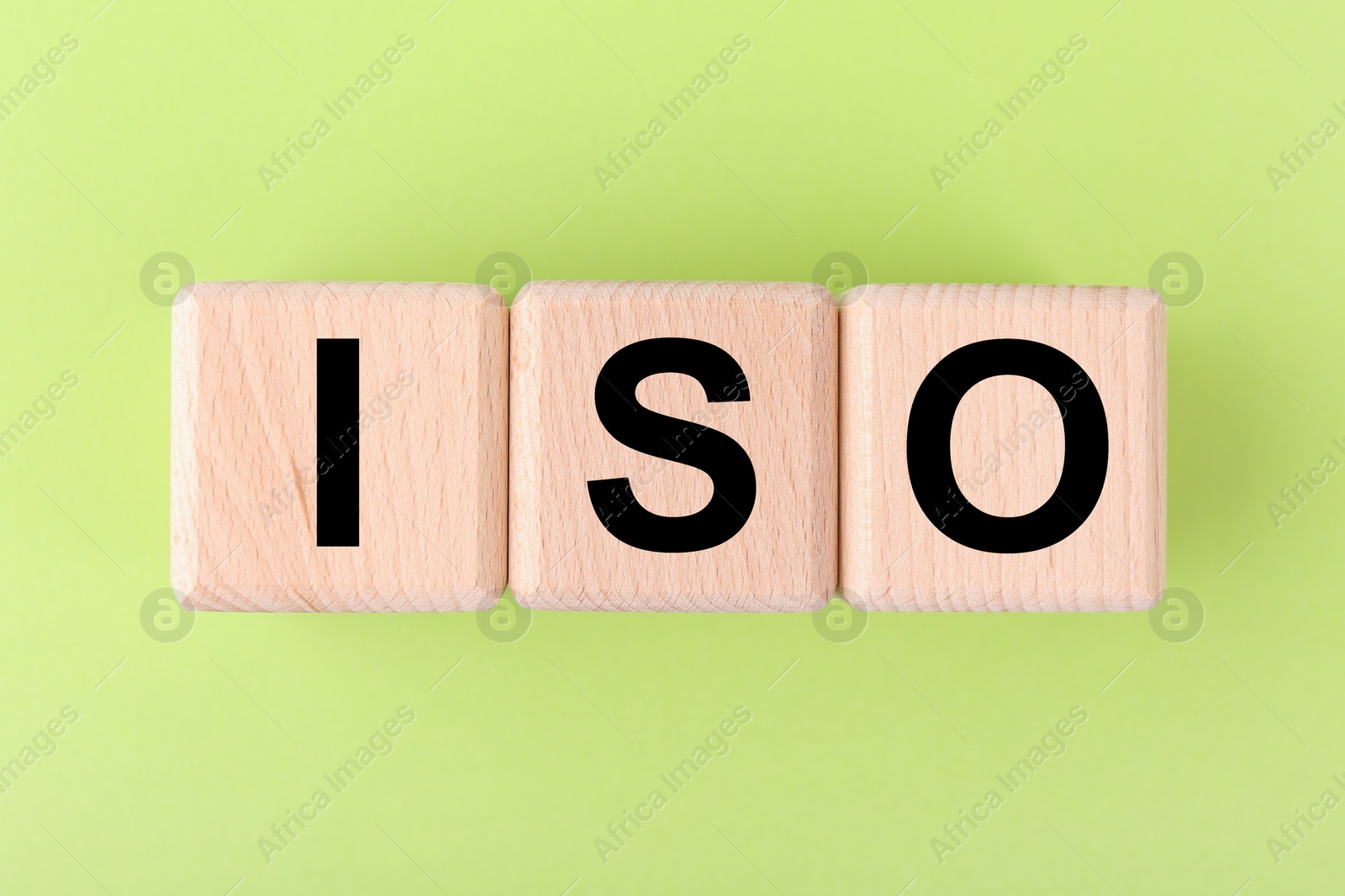 Photo of International Organization for Standardization. Wooden cubes with abbreviation ISO on light green background, top view