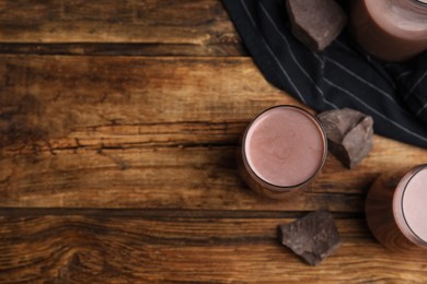 Photo of Delicious chocolate milk on wooden table, flat lay. Space for text
