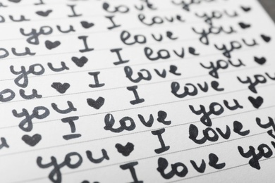 Photo of Notebook page with words I LOVE YOU and hearts as background, closeup