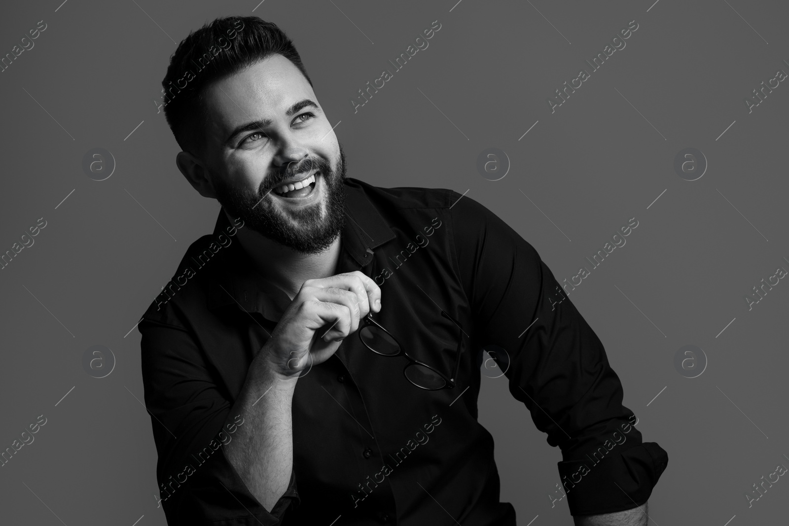 Photo of Portrait of handsome bearded man on grey background. Black and white effect