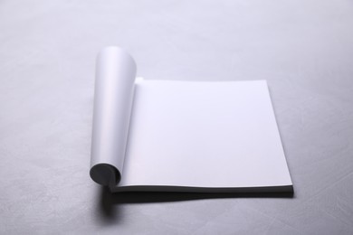 Photo of Blank paper sheets on grey textured table. Mockup for design