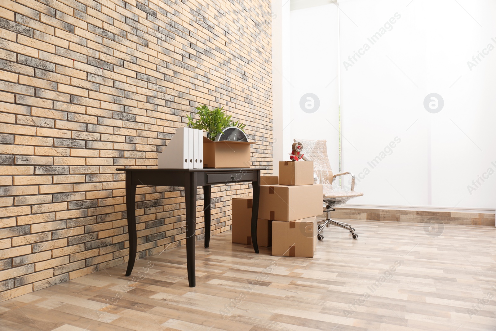Photo of Furniture and moving boxes in empty office