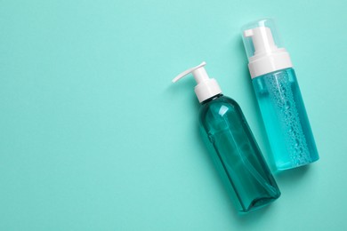Photo of Different cleansers on turquoise background, flat lay and space for text. Cosmetic product