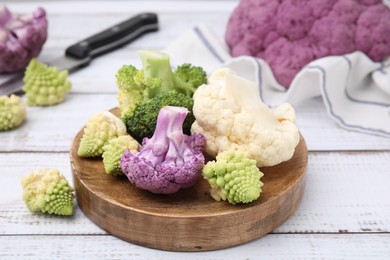 Photo of Various cauliflower cabbages on white wooden table