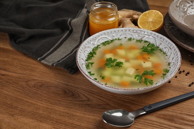 Photo of Bowl of fresh homemade soup to cure flu on wooden table. Space for text
