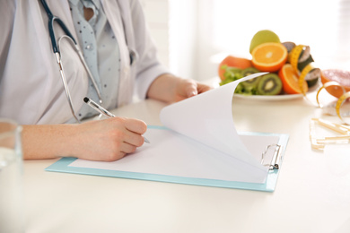 Photo of Nutritionist working at desk in office, closeup