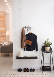 Hallway interior with stylish furniture, clothes and accessories