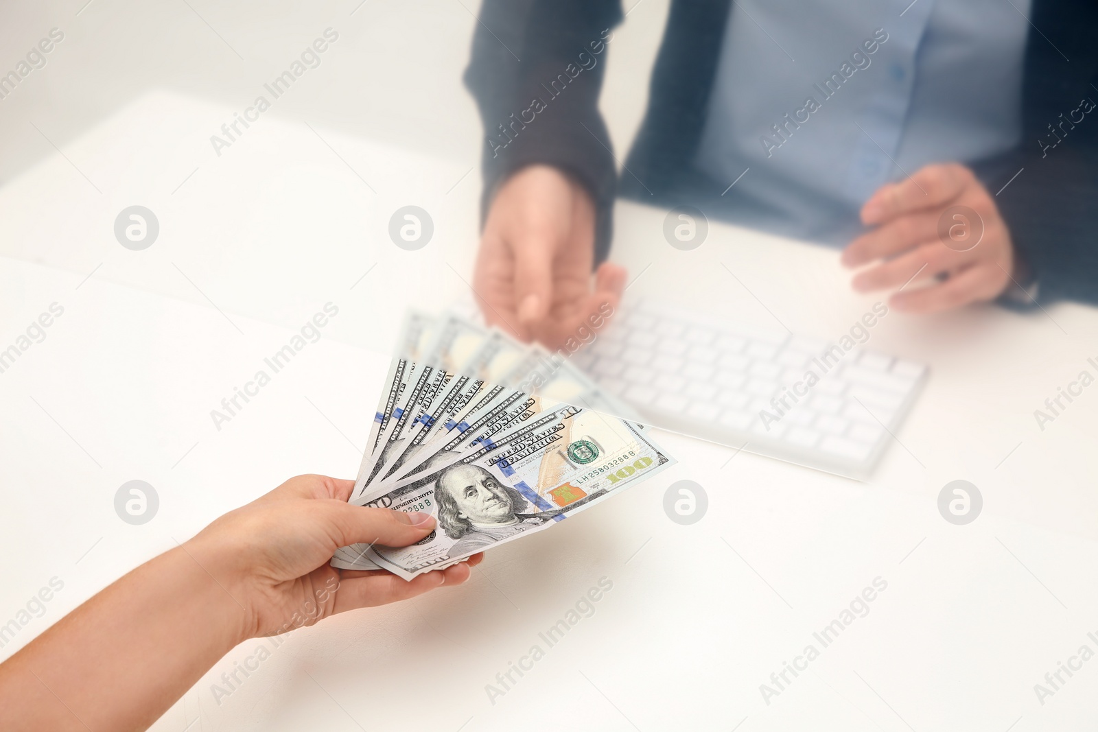 Photo of Woman giving money to teller at cash department window, closeup