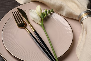 Photo of Stylish table setting. Plates, cutlery, napkin and floral decor on background, closeup