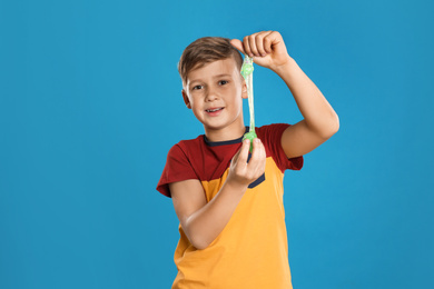 Photo of Preteen boy with slime on blue background