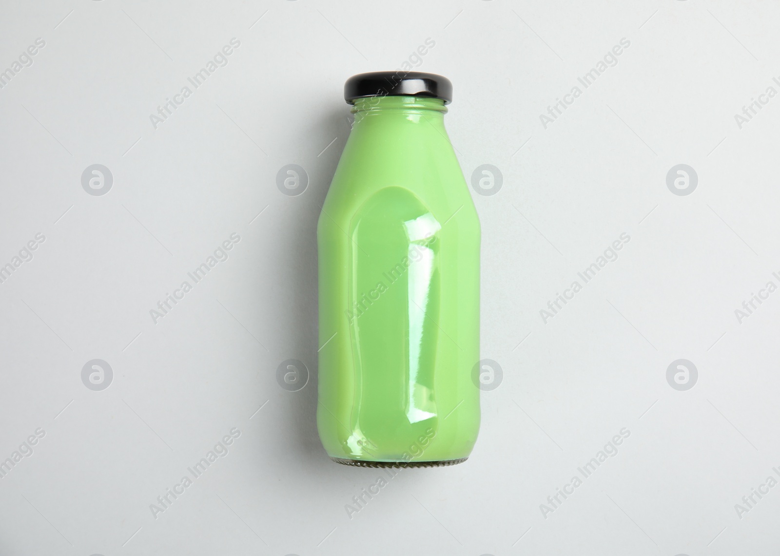 Photo of One bottle with tasty drink on color background, top view