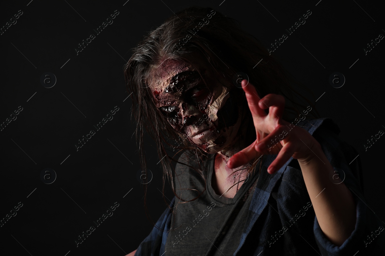 Photo of Scary zombie on dark background. Halloween monster