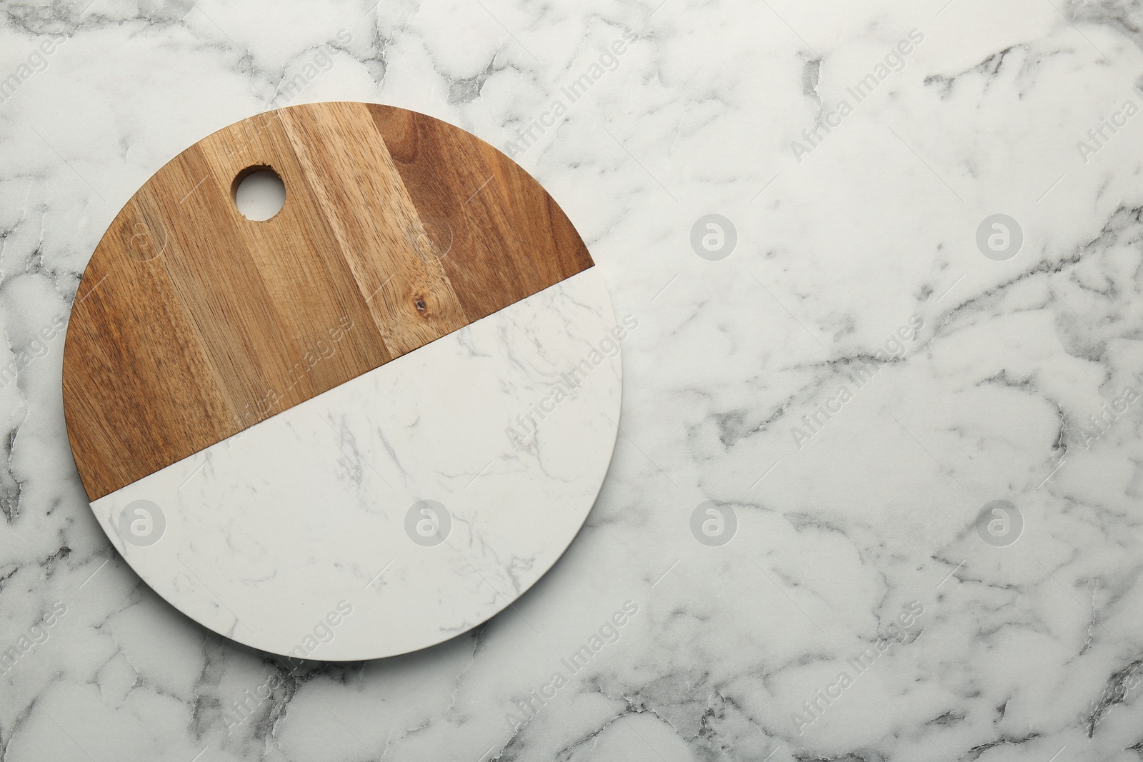 Photo of Serving board on white marble table, top view. Space for text