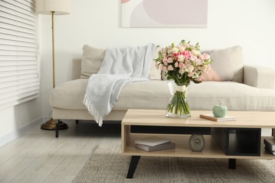 Photo of Beautiful bouquet of fresh flowers in vase on wooden table indoors