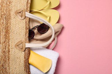 Photo of Flat lay composition with wicker bag and other beach accessories on pink background. Space for text