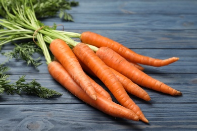 Photo of Bunch of fresh juicy carrots on wooden background