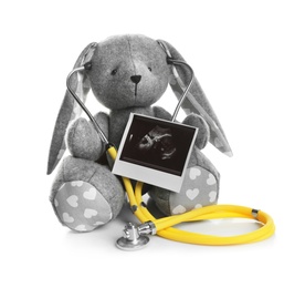 Ultrasound photo of baby and toy rabbit on white background. Concept of pregnancy