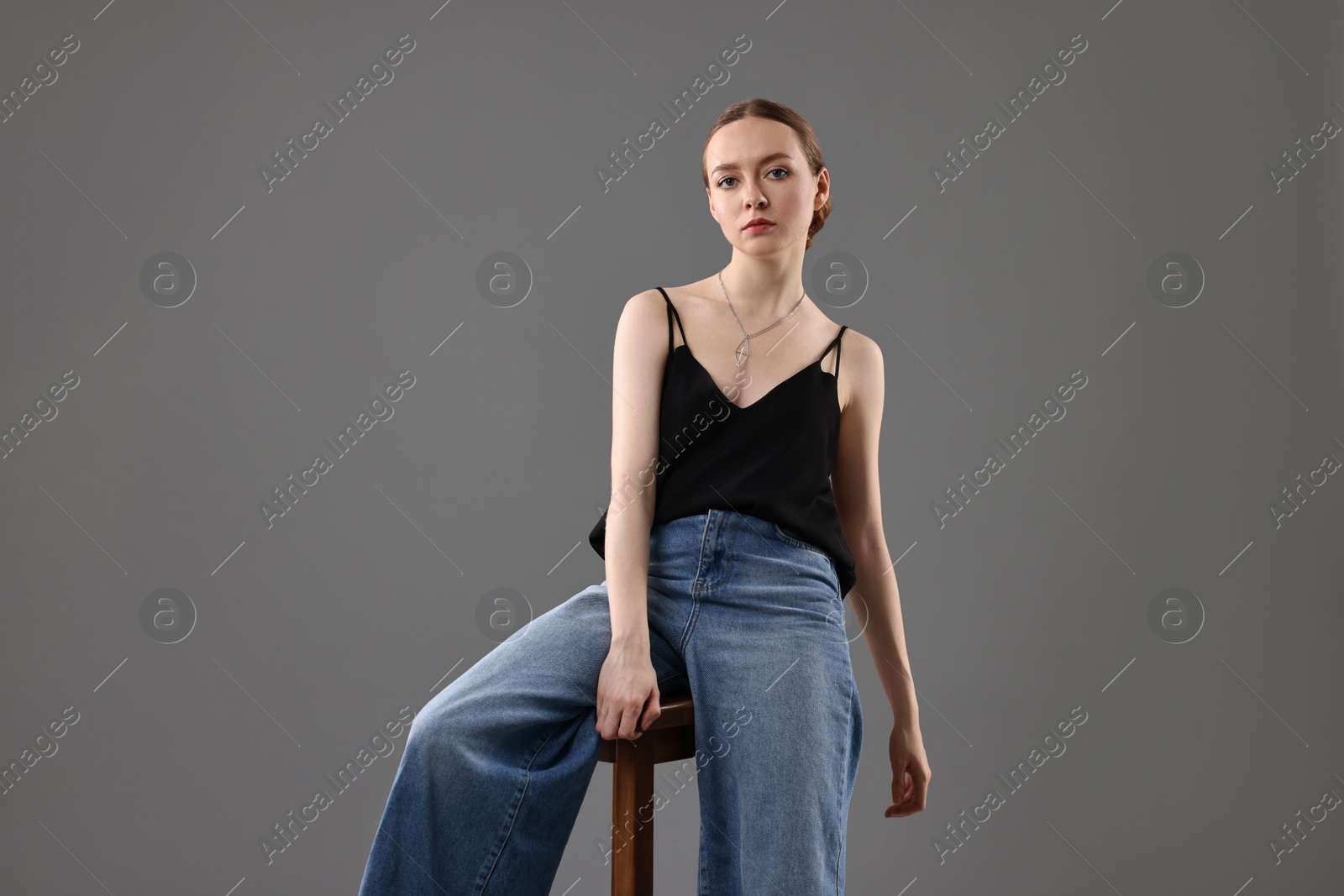 Photo of Fashionable portrait of beautiful young woman on grey background