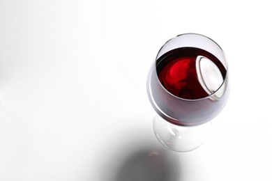 Glass of red wine on white background, above view. Space for text