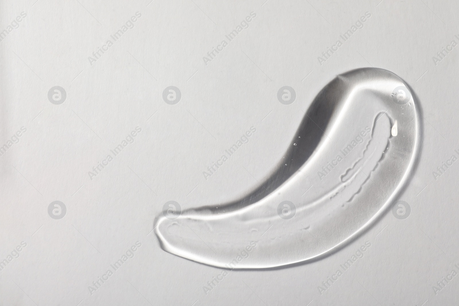 Photo of Sample of transparent cosmetic gel on white background, top view. Space for text