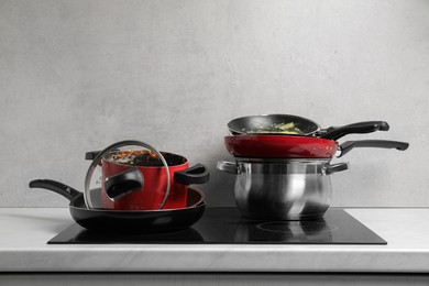 Photo of Stacks of dirty kitchenware on cooktop in kitchen