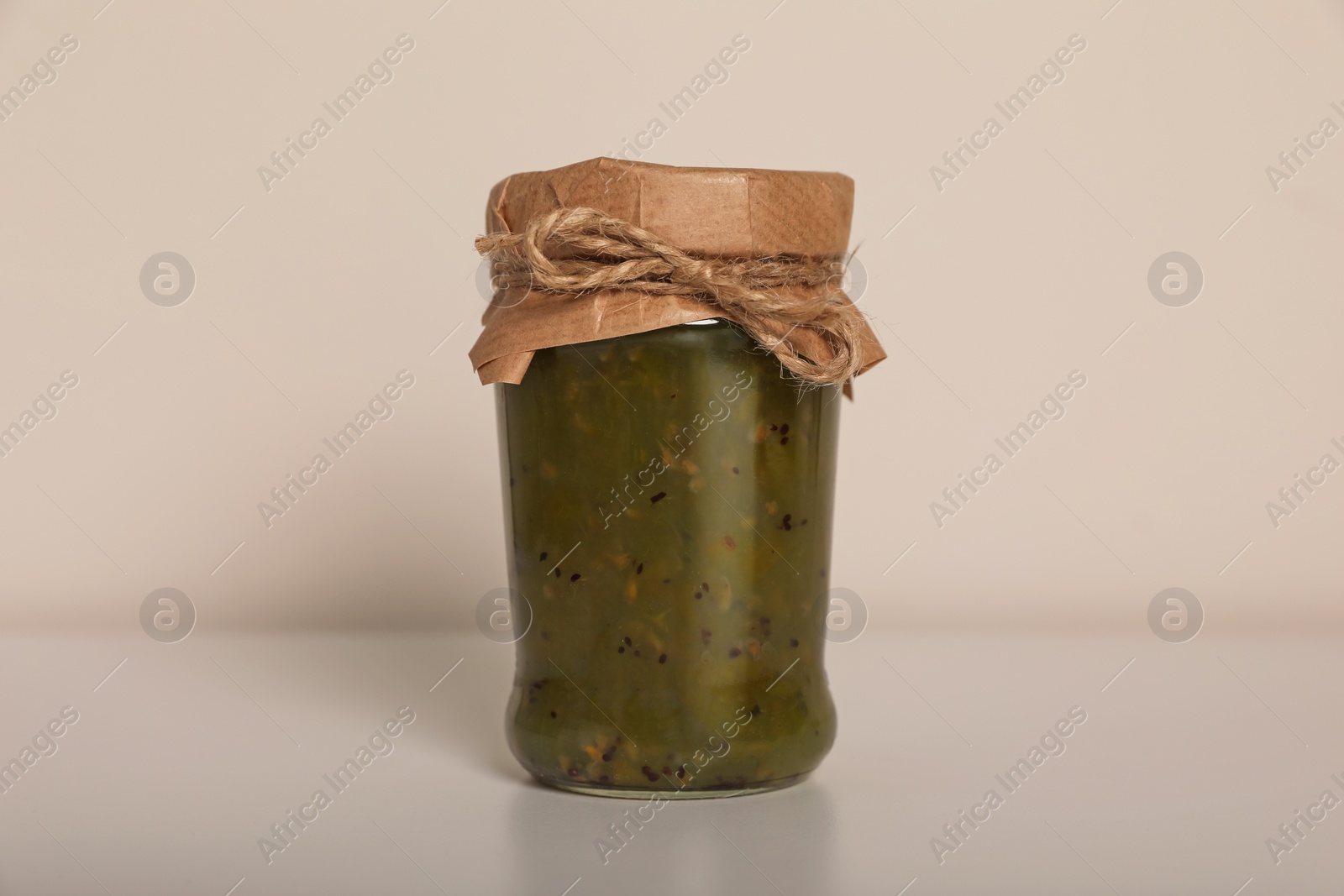 Photo of Tasty canned kiwi jam on white background