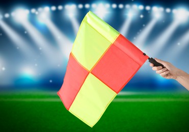 Referee holding linesman flag at stadium, closeup