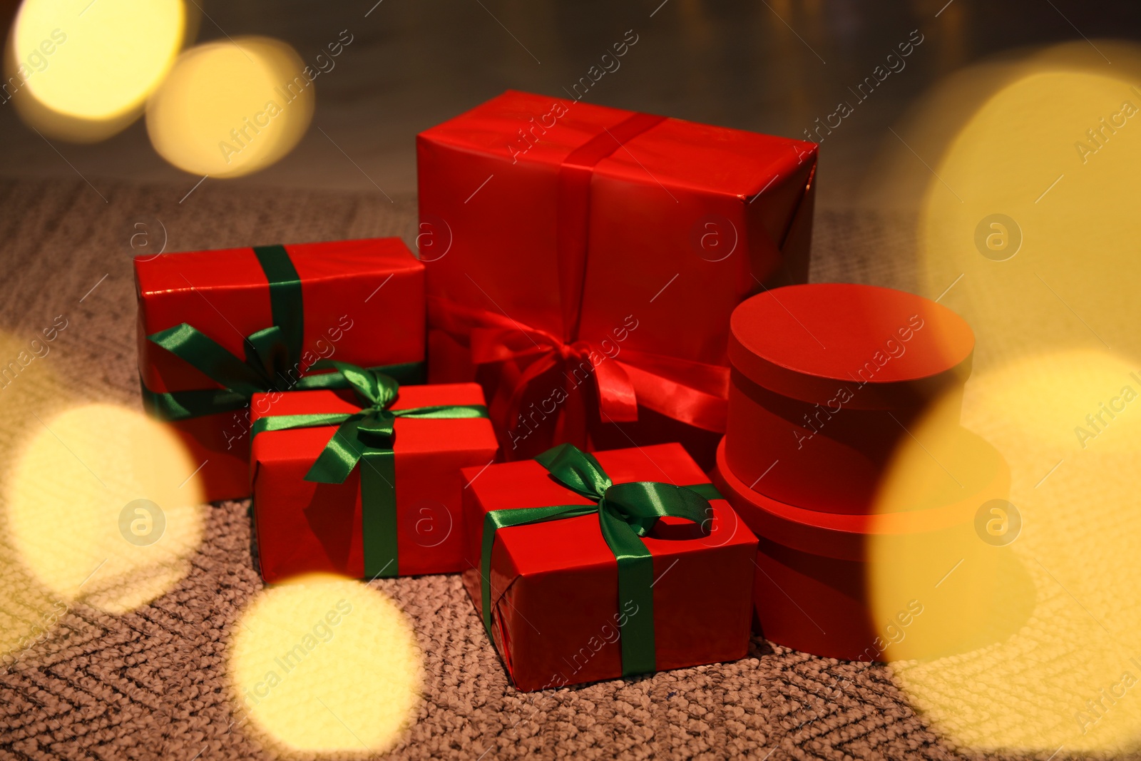 Photo of Beautifully wrapped Christmas gifts on rug indoors