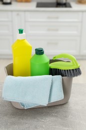 Different cleaning supplies in basket on table
